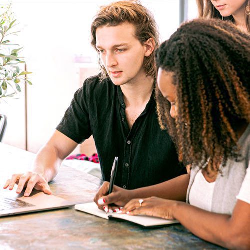 Three individuals studying enthusiastically.